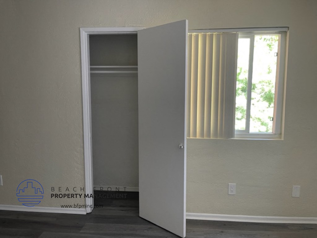 an open closet in a room with a window