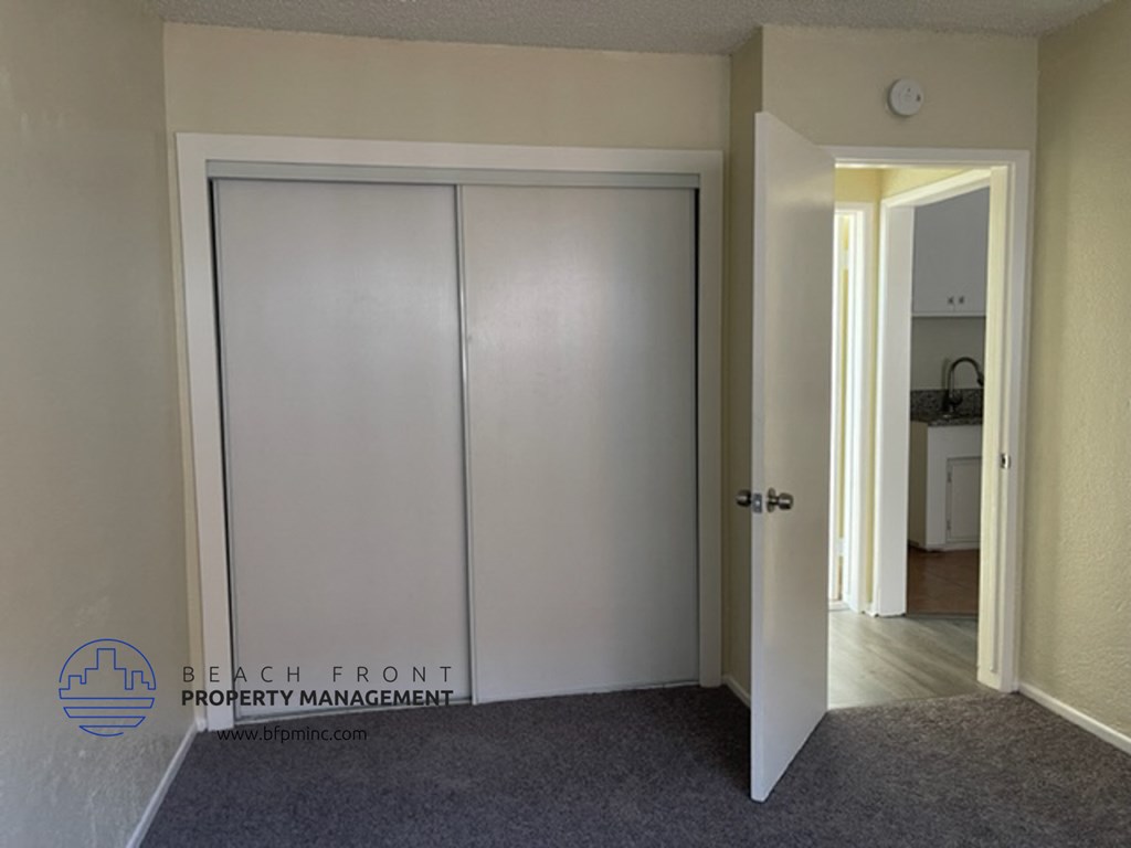 a closet in a room with a door open and a door to a hallway