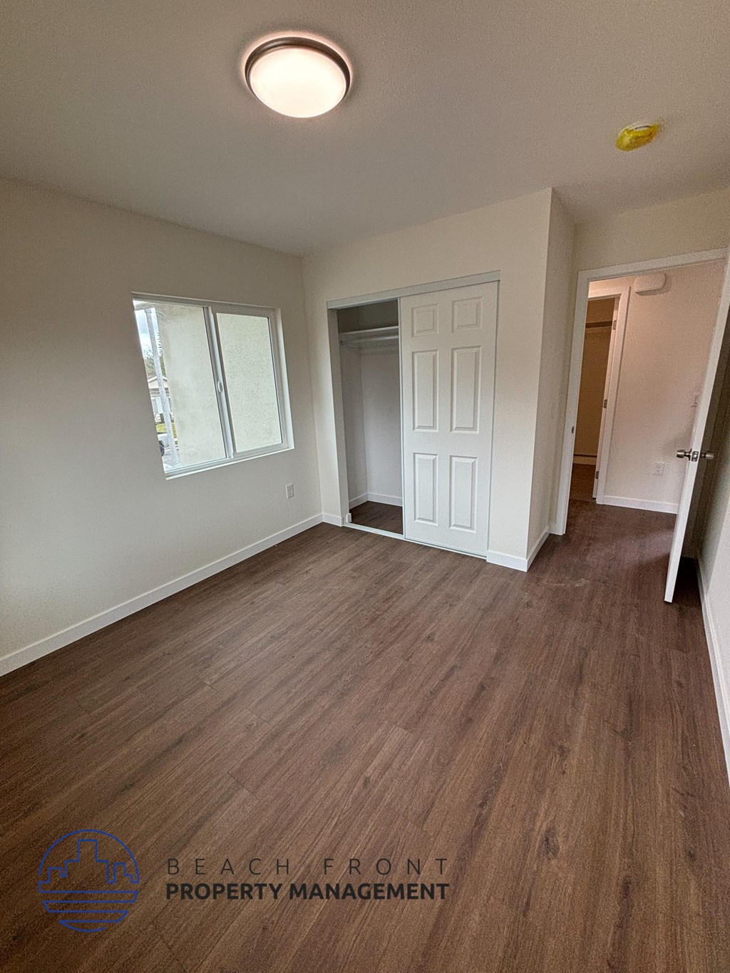 A room with wooden flooring and a white door.