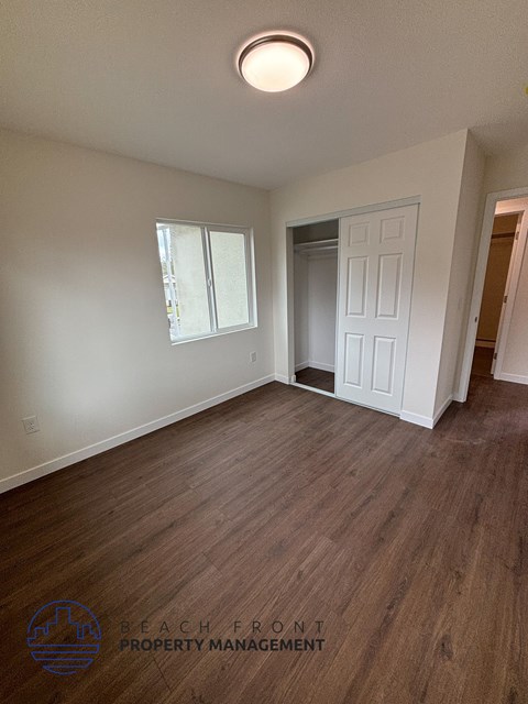 A room with wooden flooring and a white door.