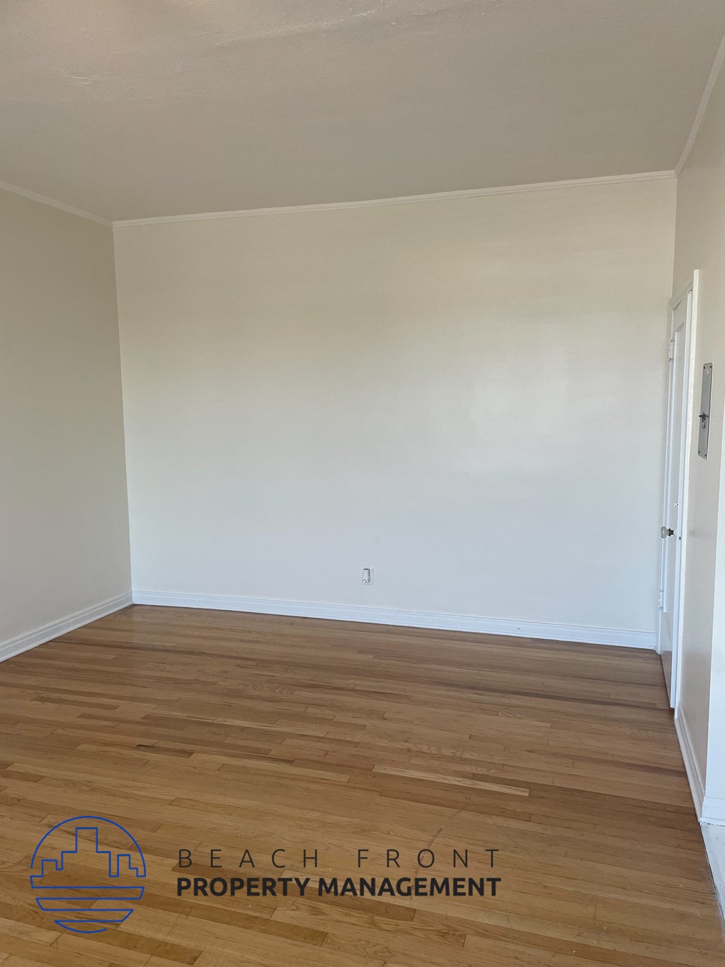 an empty room with wood floors and white walls