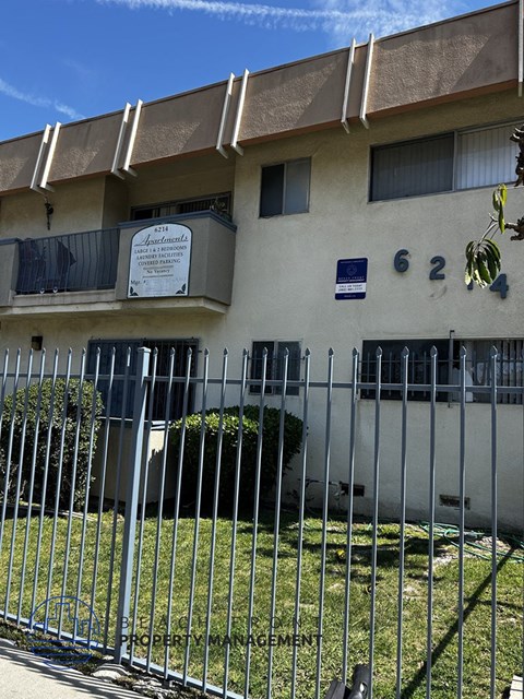 A white building with a sign that says "Apartments" on it.