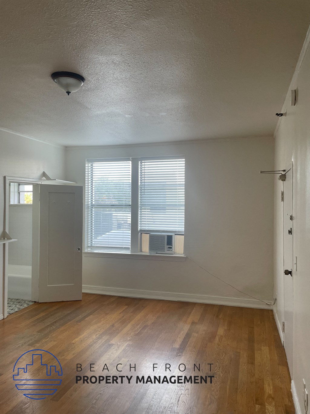 an empty room with a window and a closet