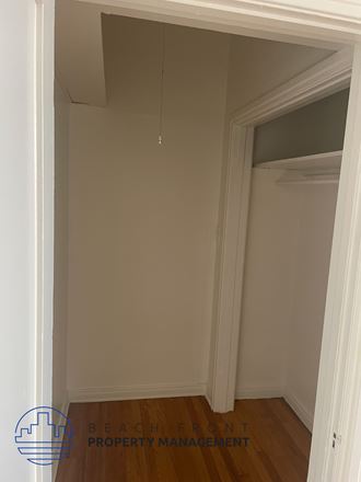 a small room with a door to a closet and a wood floor