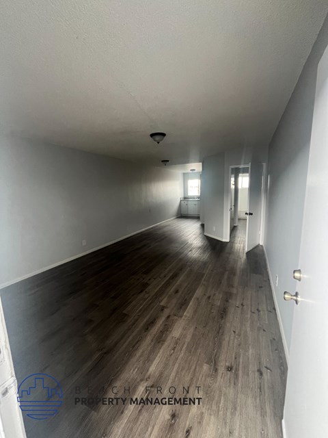 A long hallway with wooden floors and white walls.