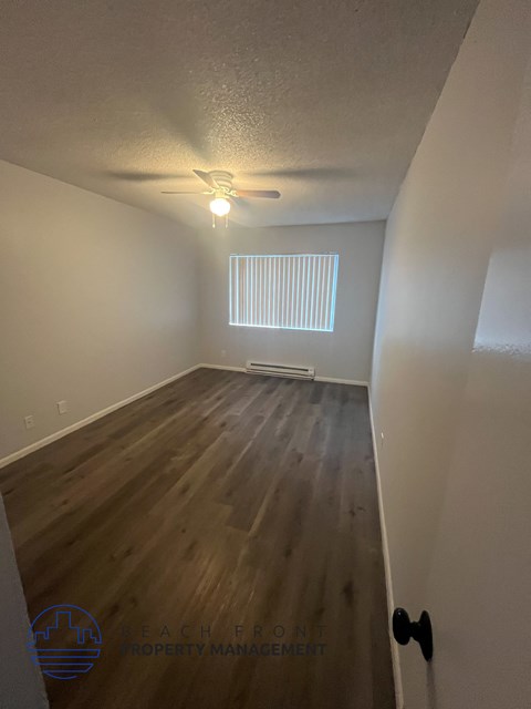 A room with wooden floors and a ceiling fan.