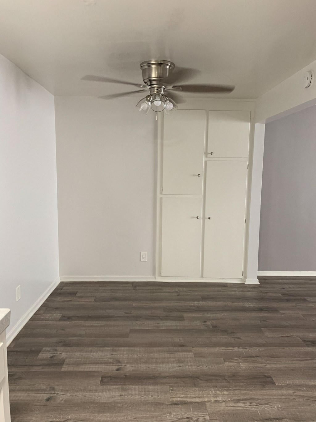 an empty room with a ceiling fan and white closet
