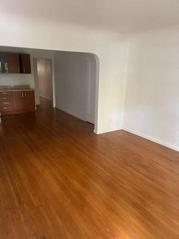 an empty living room with a wooden floor