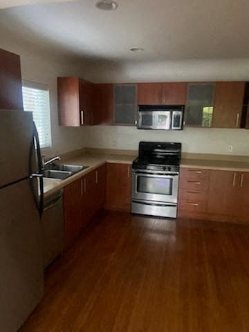 a kitchen with wooden floors and stainless steel appliances