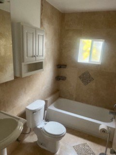 a bathroom with a toilet and a bath tub