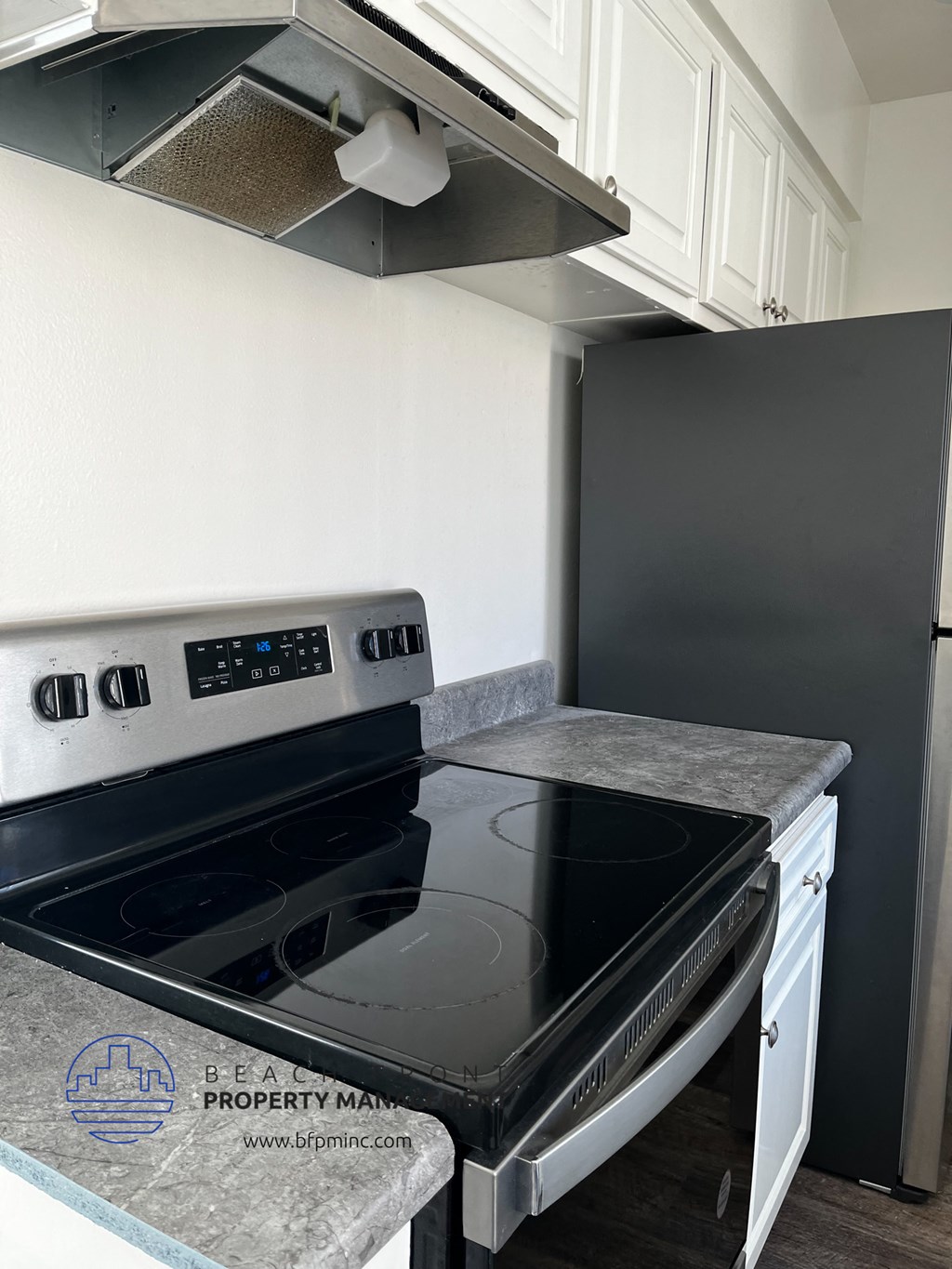 an empty kitchen with a stove and a refrigerator