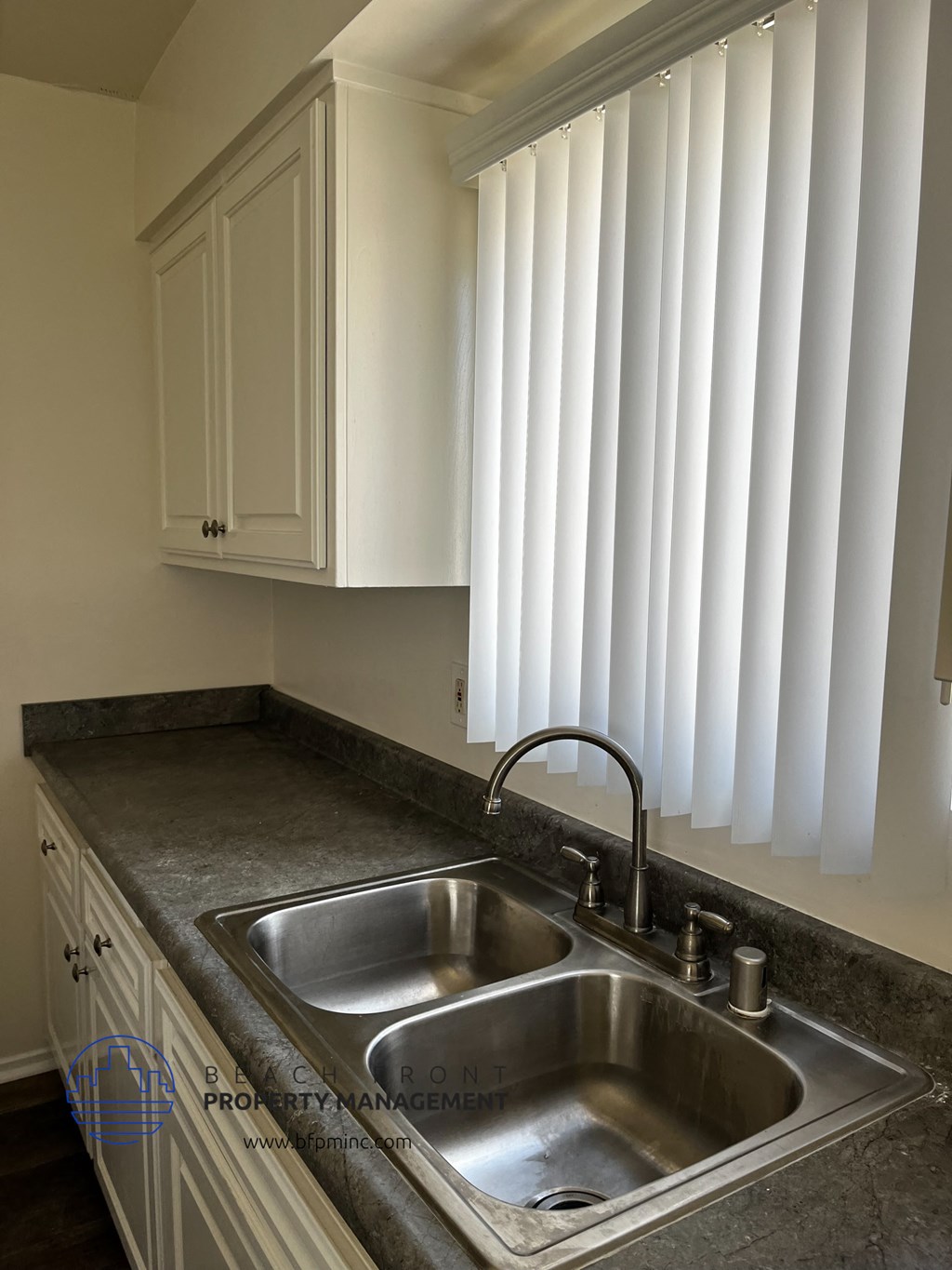 a kitchen with a sink and white cabinets
