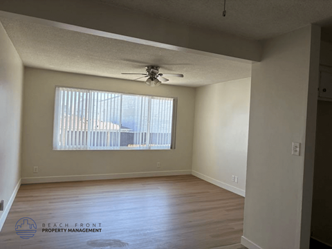 A room with a ceiling fan and a window with blinds.