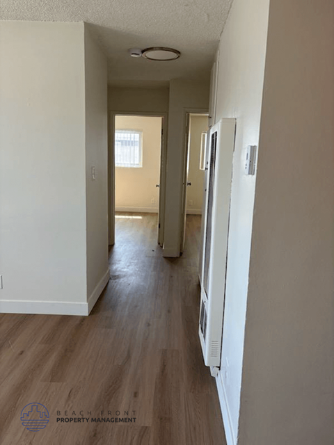 A long hallway with a logo for Beach Front Property Management in the bottom left corner.