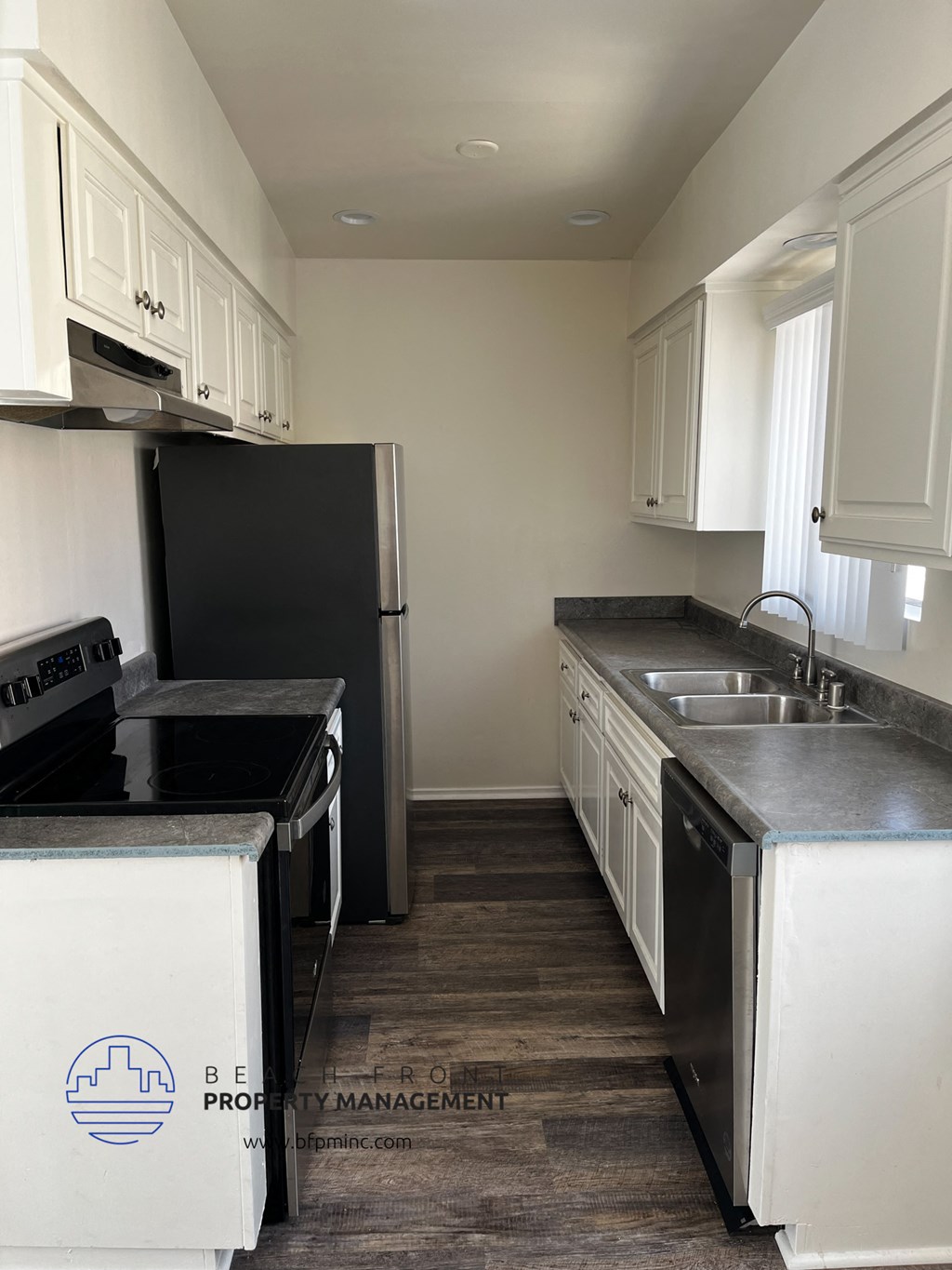 a kitchen with white cabinets and black appliances and a black refrigerator