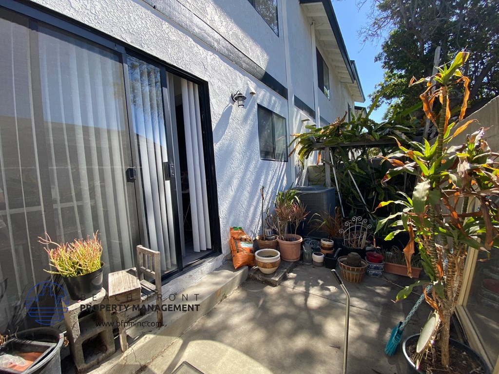 a patio with potted plants in front of a house