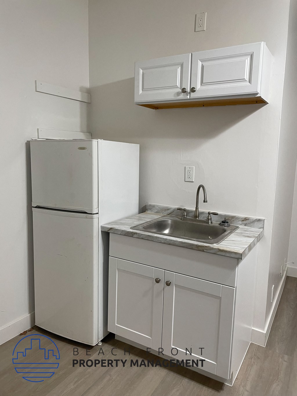 a small kitchen with a sink and a refrigerator