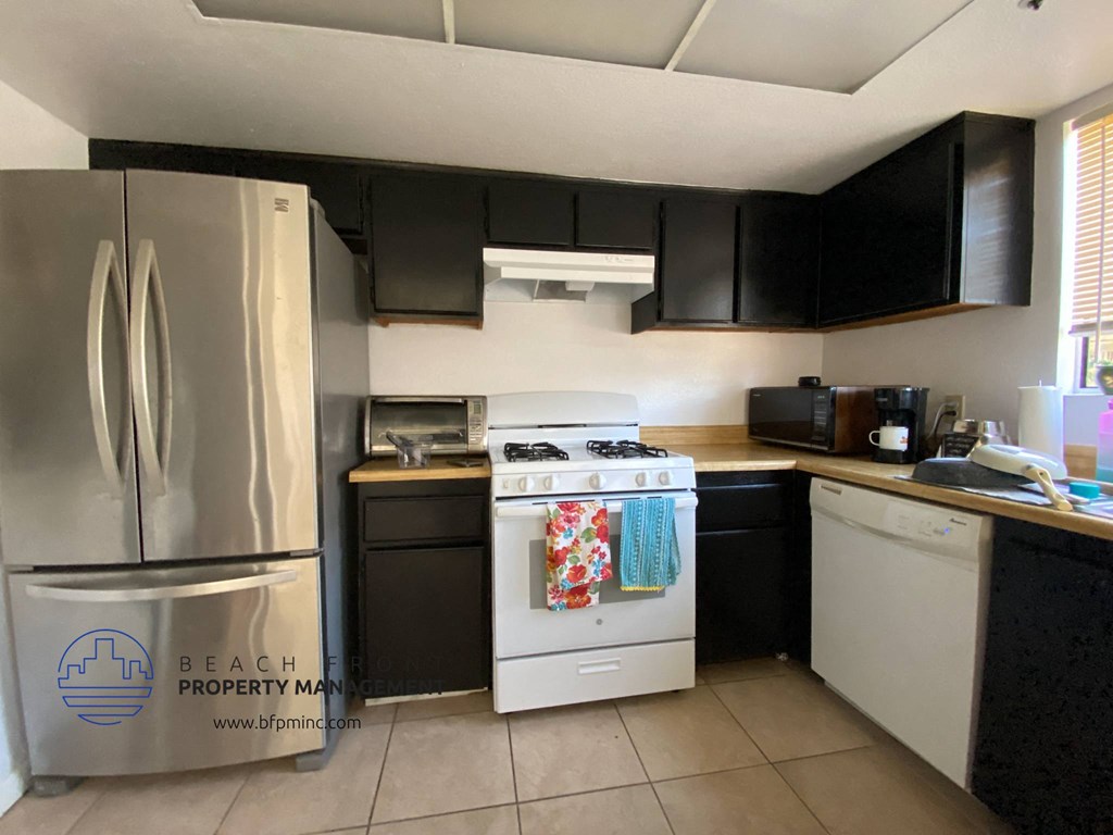 a kitchen with white appliances and black cabinets