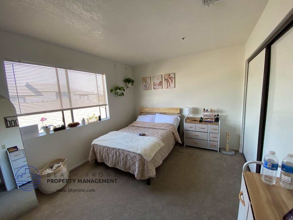 a bedroom with a bed and a dresser and a window