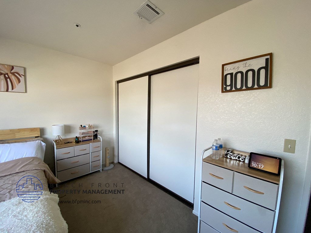 a bedroom with a closet and a bed and a dresser