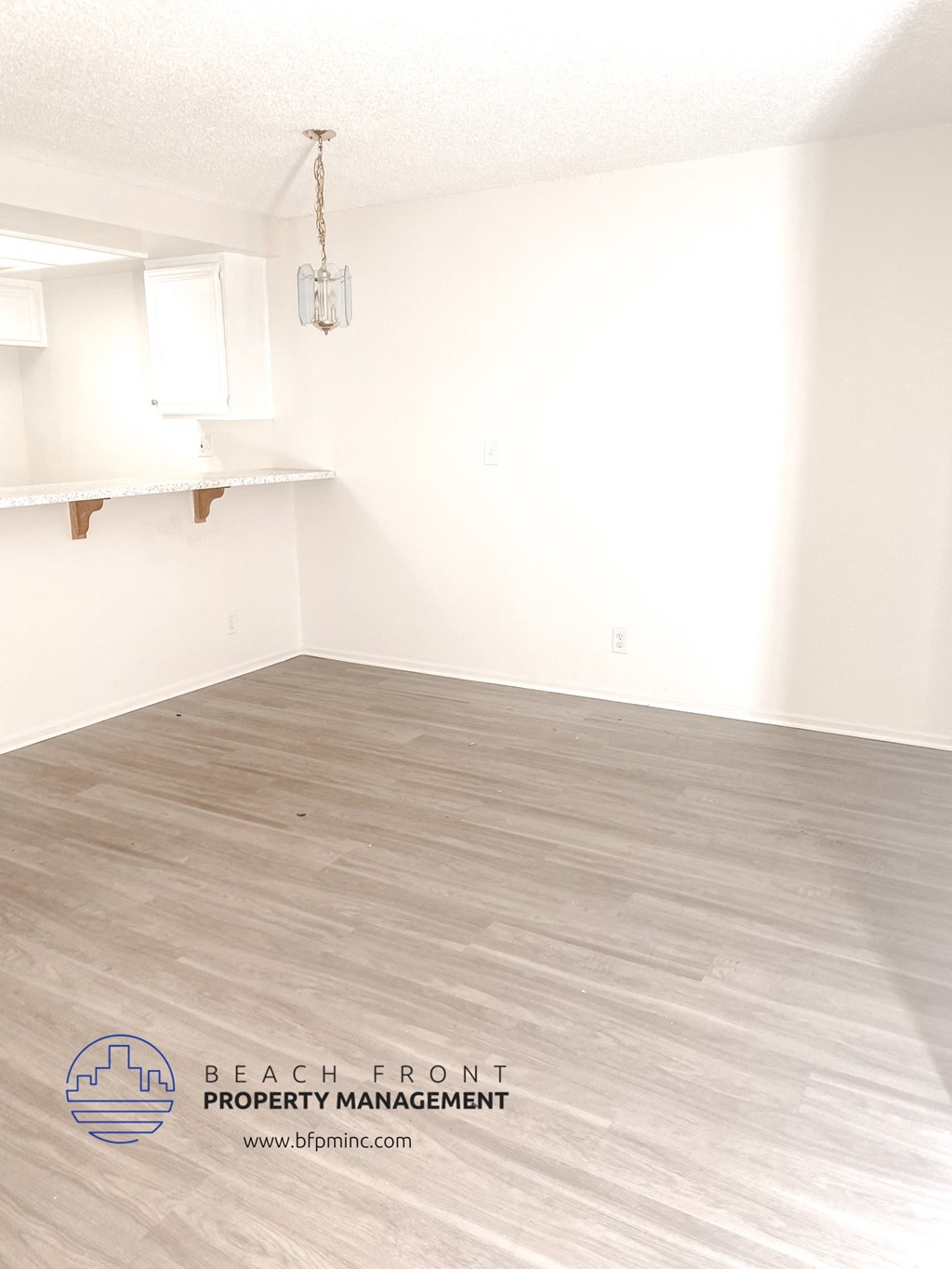 an empty living room with white walls and wood floors