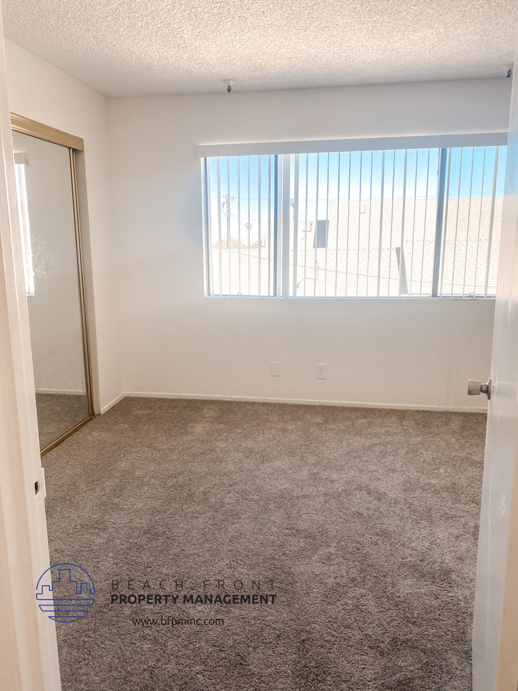 a bedroom with a carpeted floor and a window
