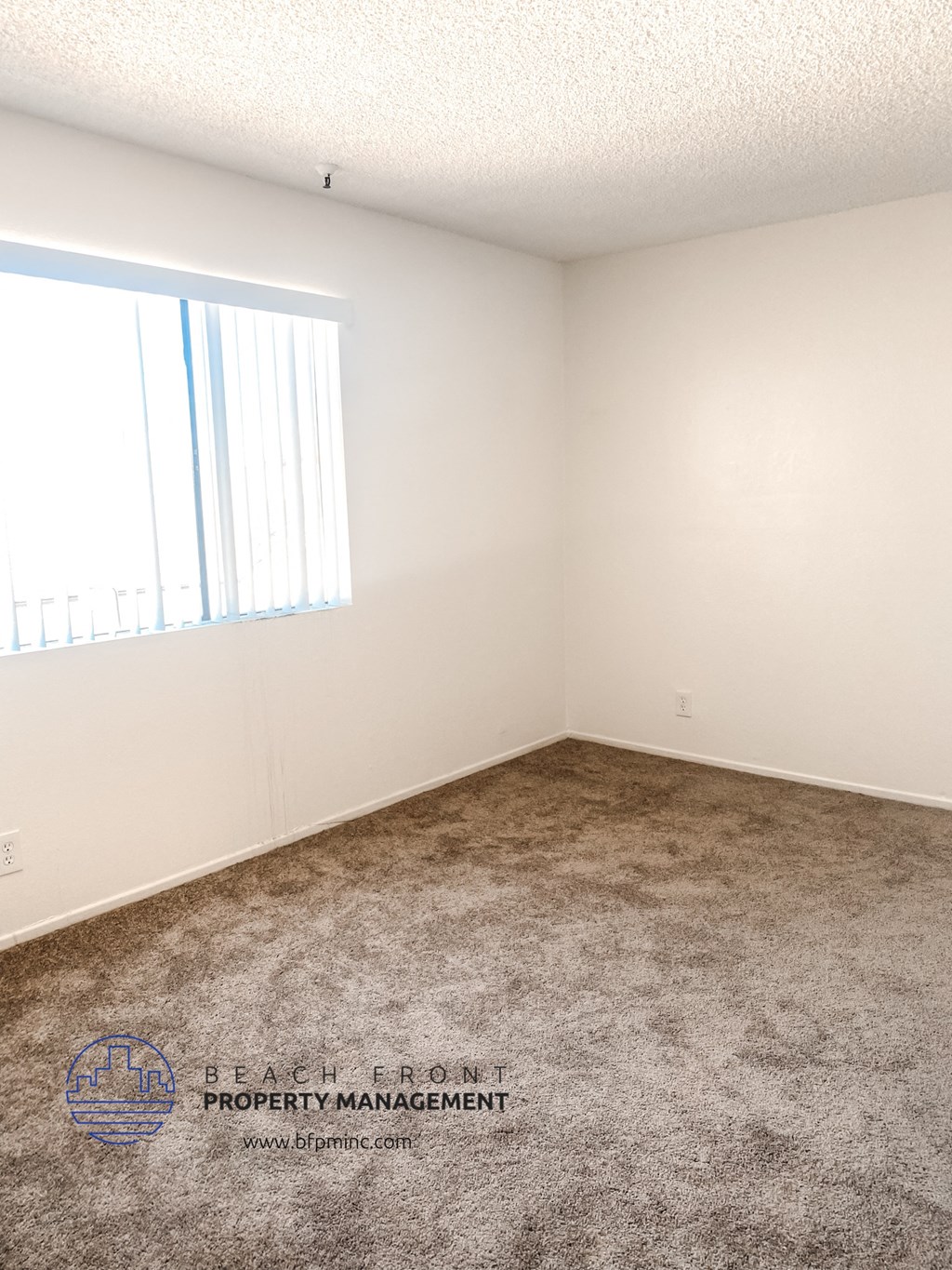 an empty room with carpet and a window
