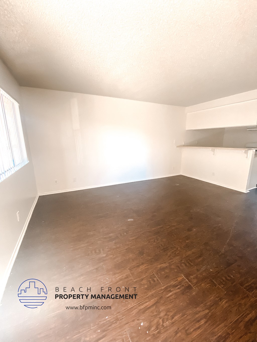 a empty room with wood floors and white walls