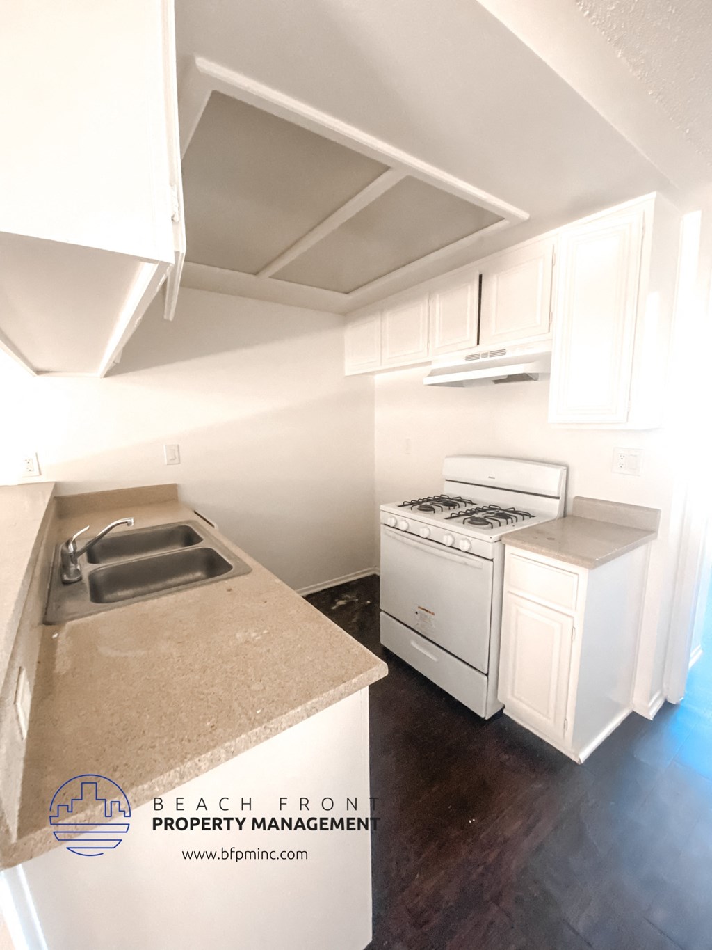 a kitchen with white cabinets and a sink and a stove