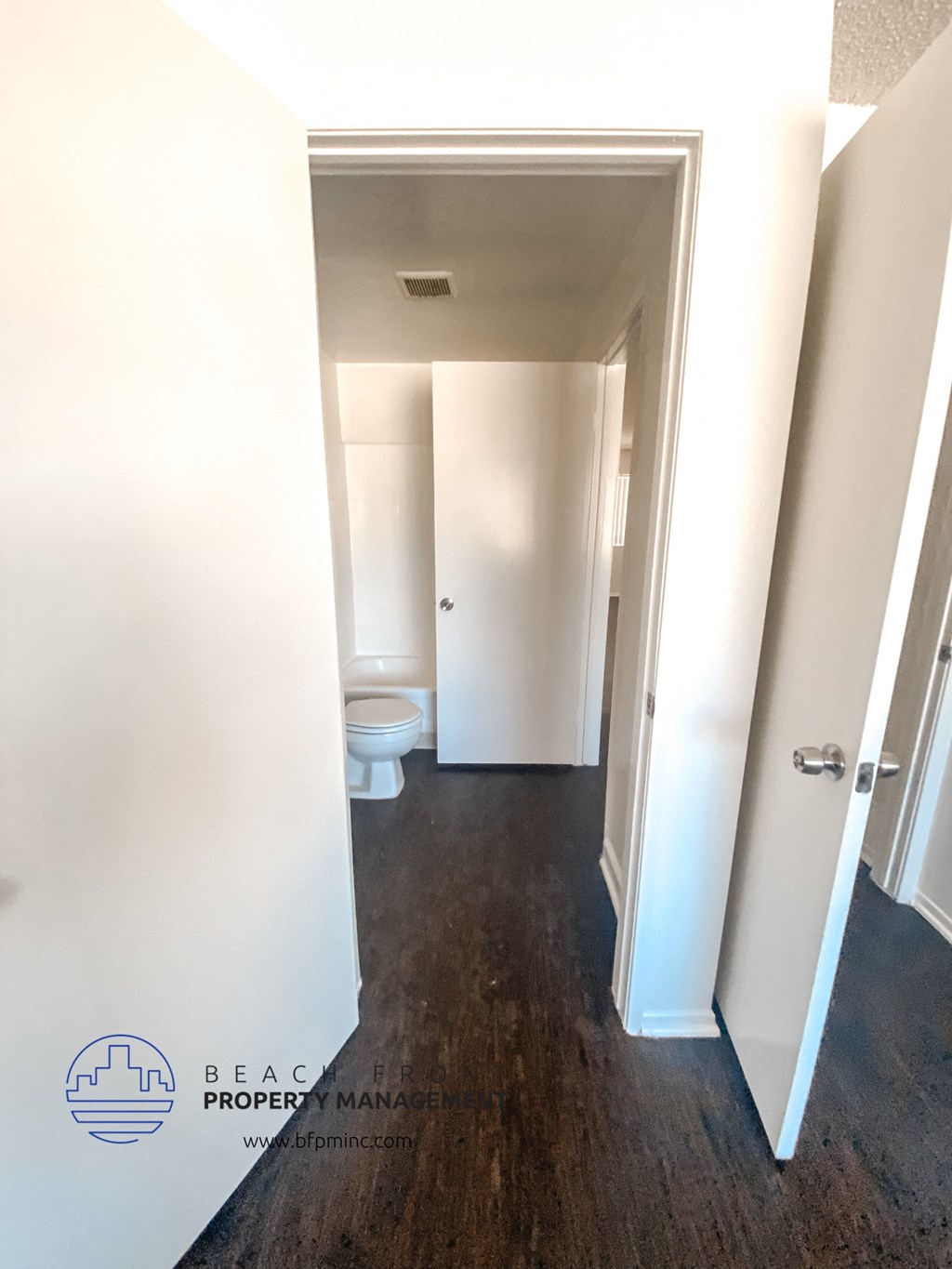 a renovated bathroom with white walls and a wooden floor