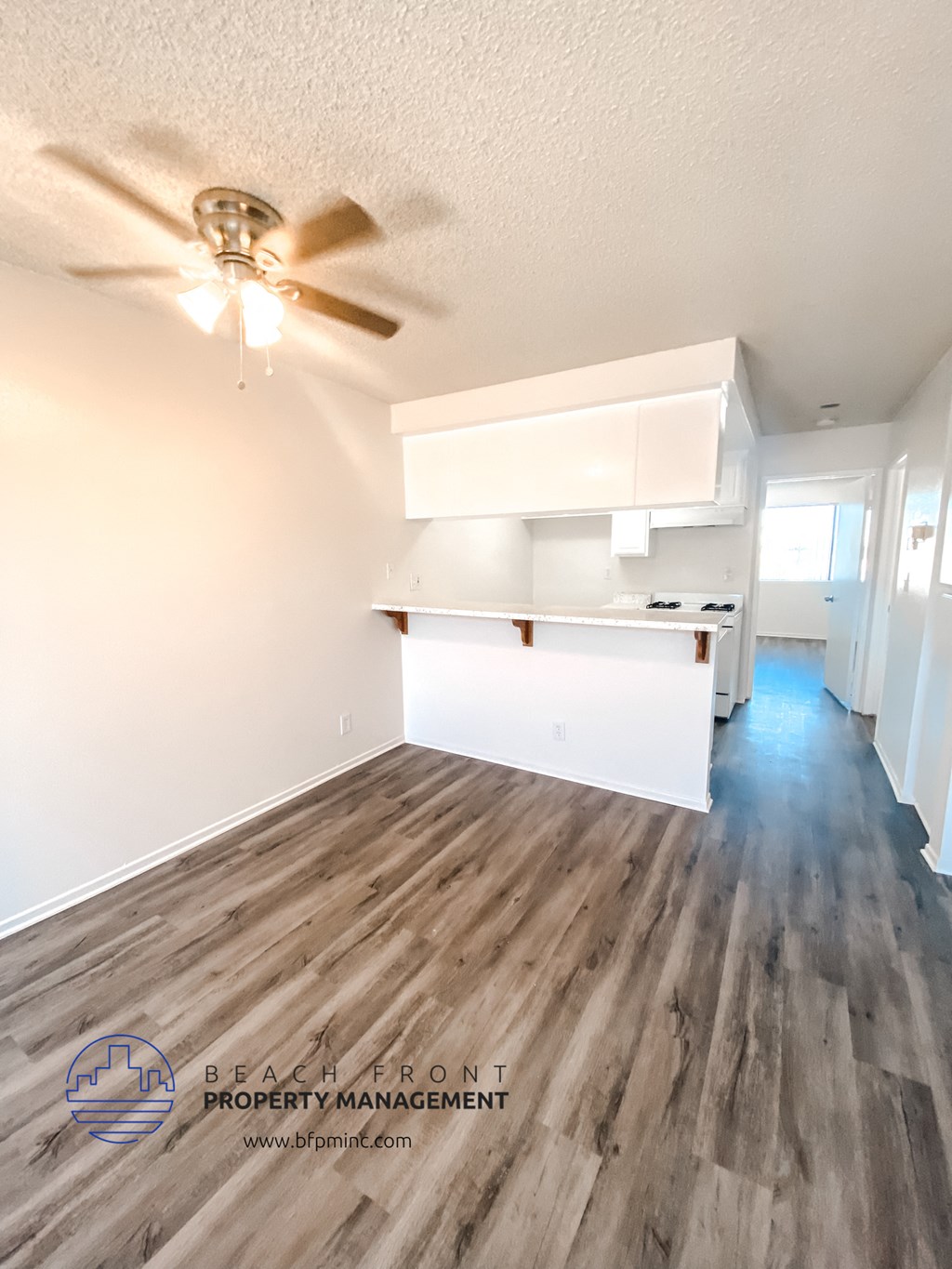the living room and kitchen of a manufactured home with wood flooring