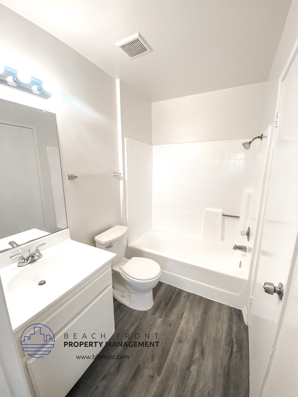 a white bathroom with a toilet and a tub and a sink