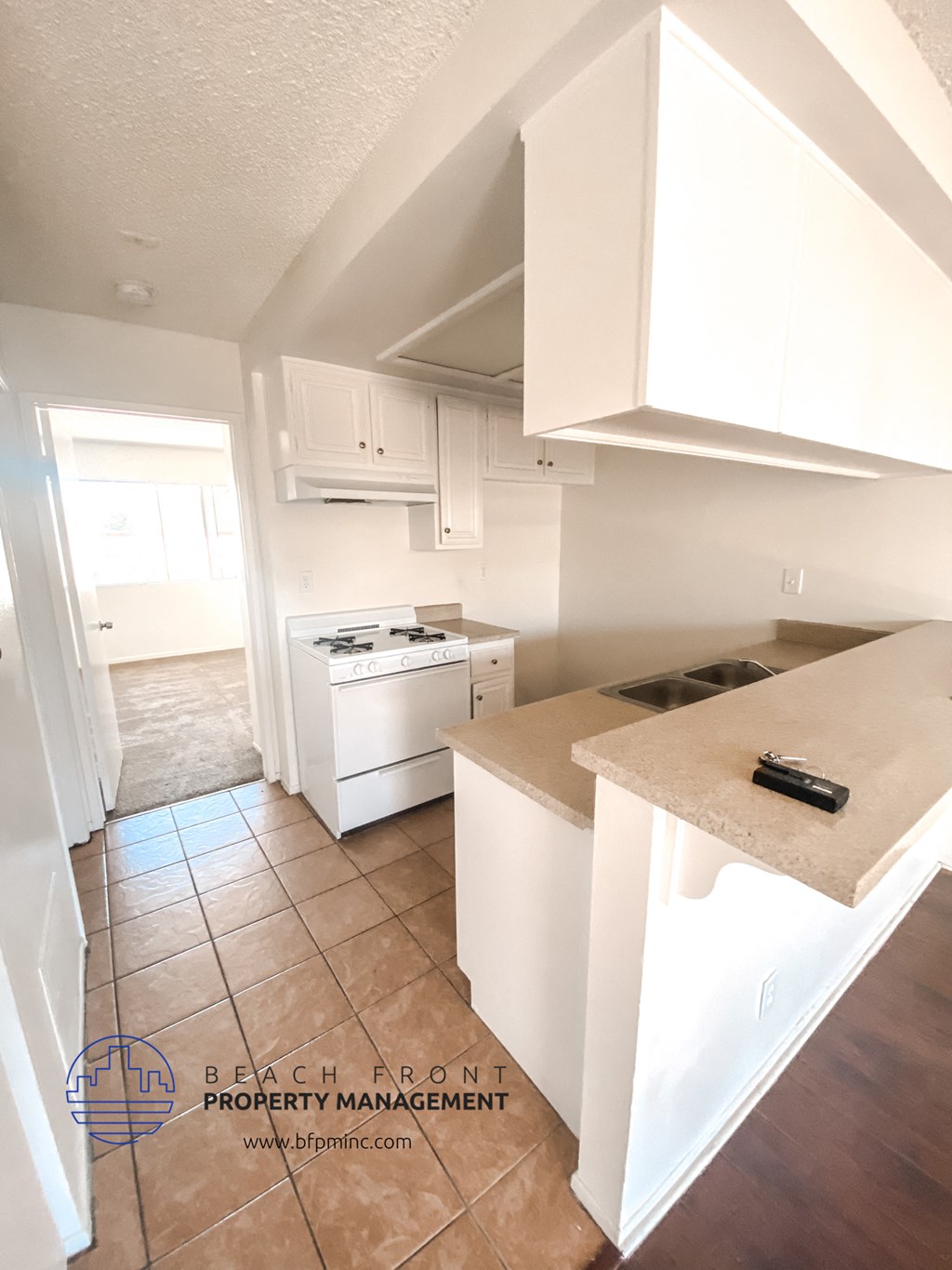 a view of a kitchen with white cabinets and a counter top