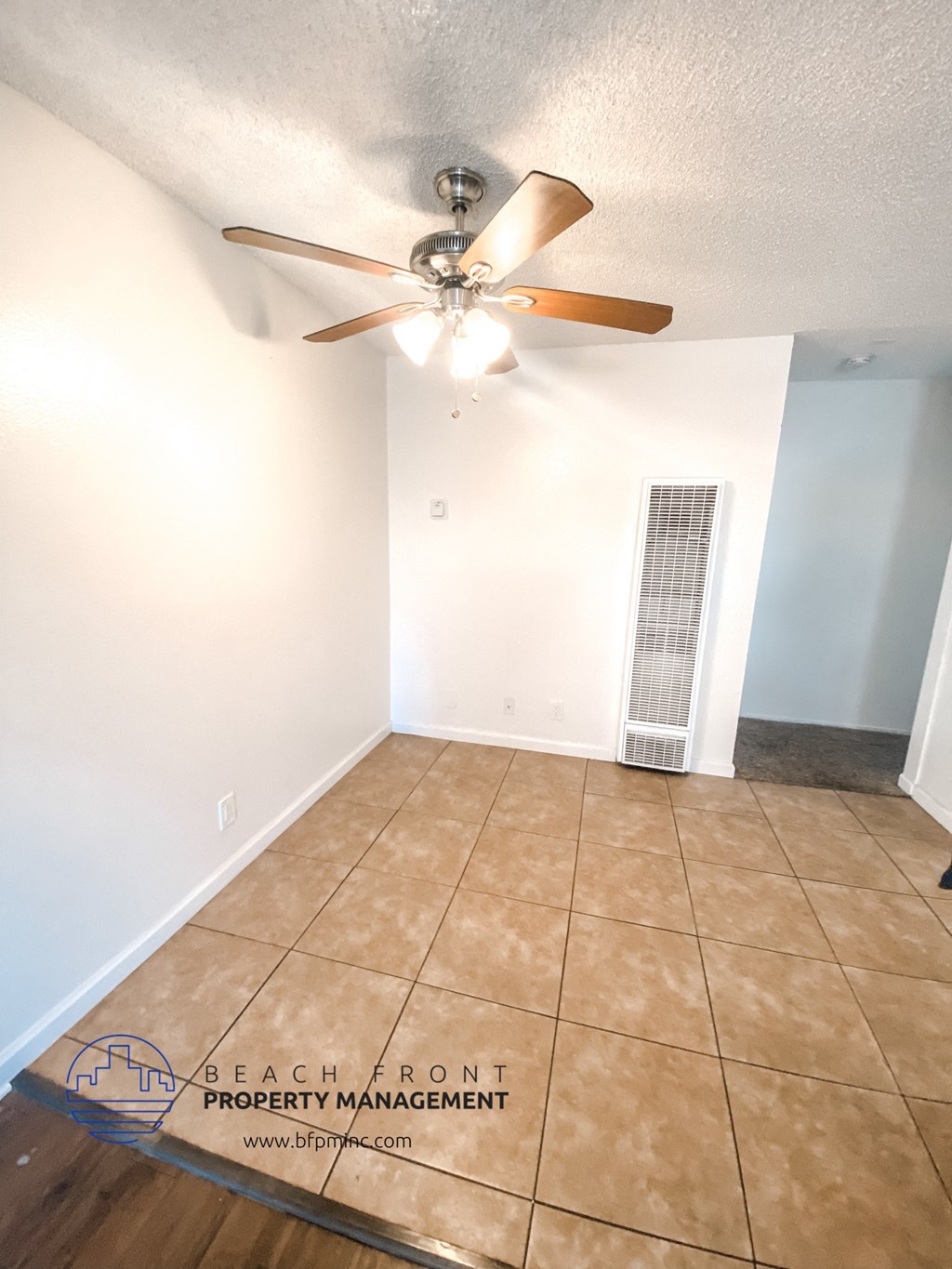 a living room with a ceiling fan and a tiled floor
