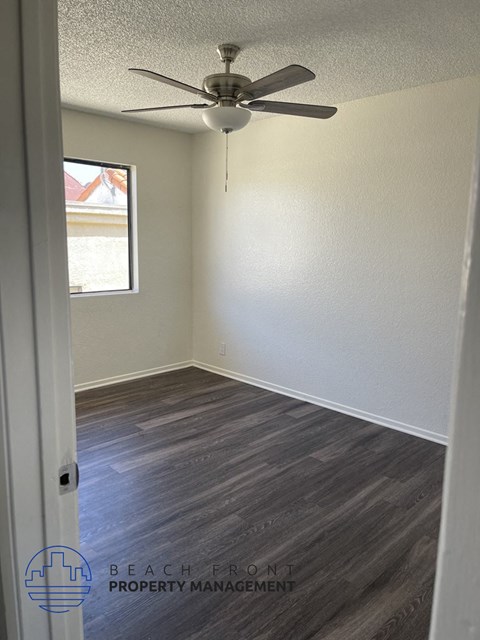 an empty room with a ceiling fan and a window