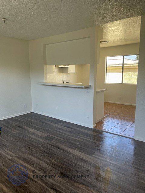 an empty living room with a kitchen in it