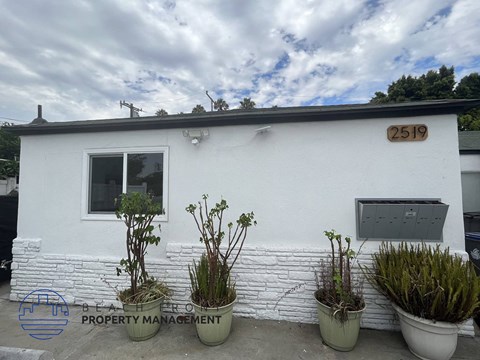 a white building with potted plants in front of it