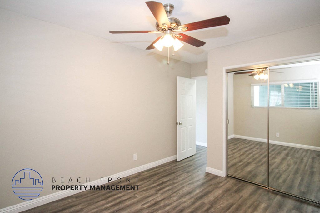 a living room with a ceiling fan and a mirror