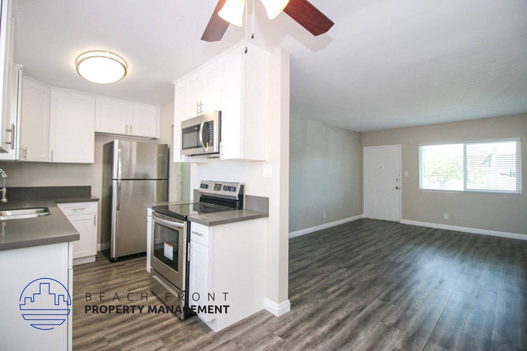a renovated kitchen with white cabinets and stainless steel appliances