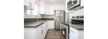 a kitchen with white cabinets and stainless steel appliances