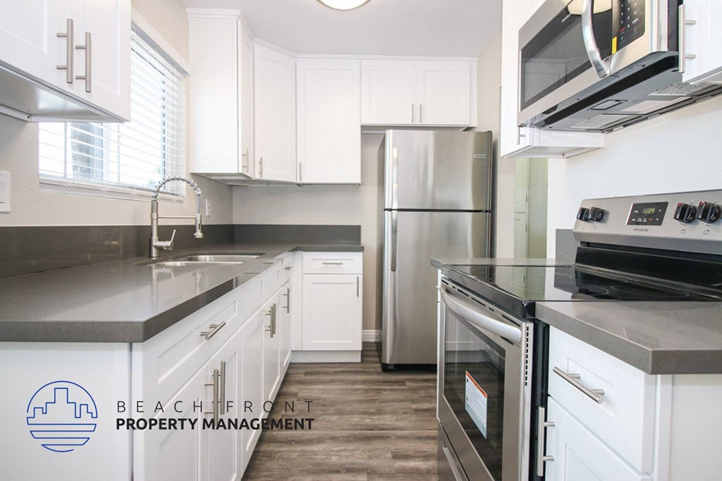 a kitchen with white cabinets and stainless steel appliances