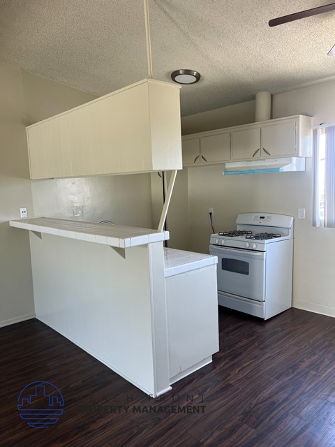 A kitchen with a white counter and a white oven.
