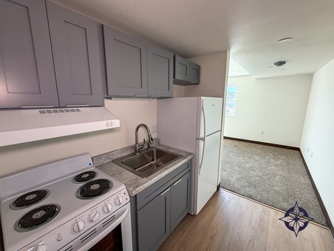 A kitchen with a white stove and a white refrigerator.