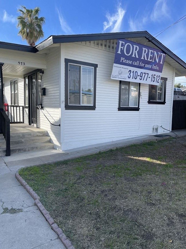 a white building with a for rent sign on it
