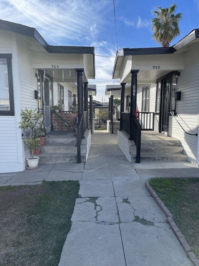 a sidewalk in front of a row of houses