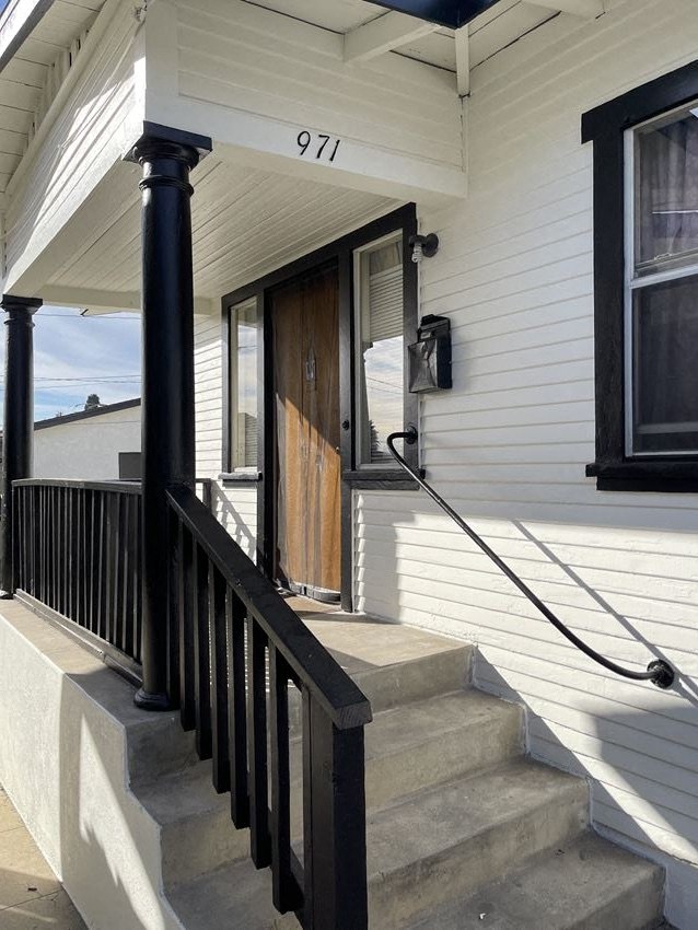 the front of a house with stairs and a door
