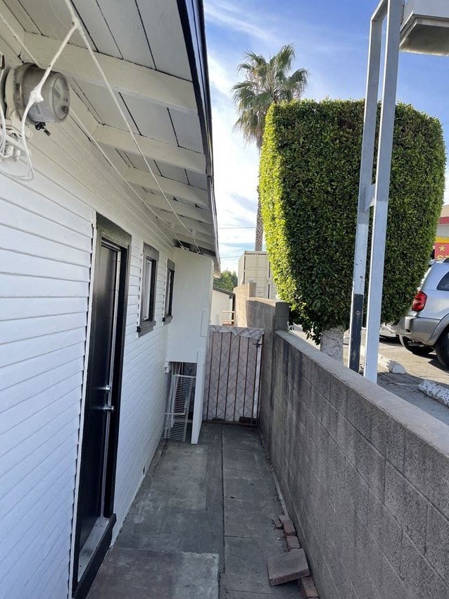 the front door of a white house with a sidewalk and a gate