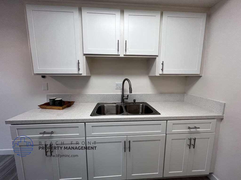 a kitchen with white cabinets and white countertops