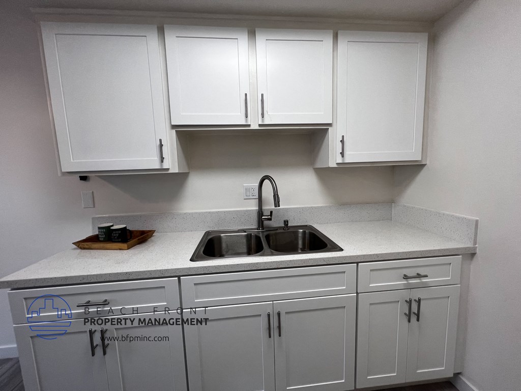 a kitchen with white cabinets and white countertops