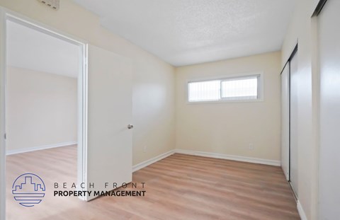 A room with a door and a window, managed by Beach Front Property Management.